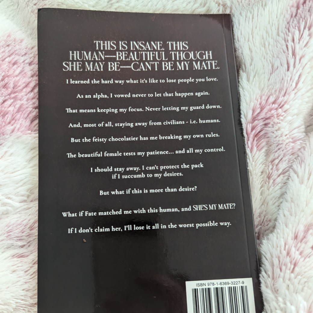 Photo of the back of the alternate cover of "Alpha's Revenge." In white text is the book blurb. 